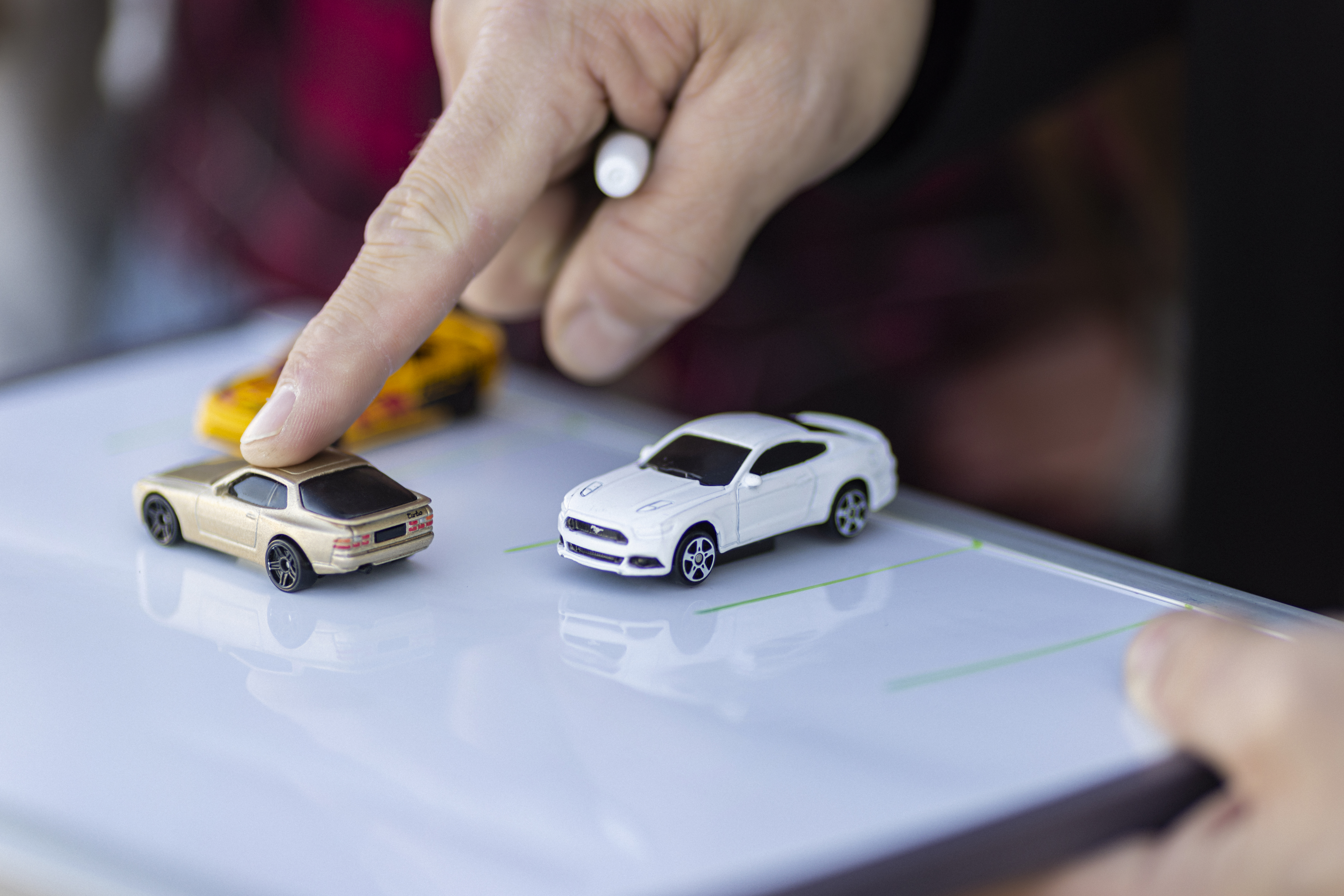 instructor with car models inside a car