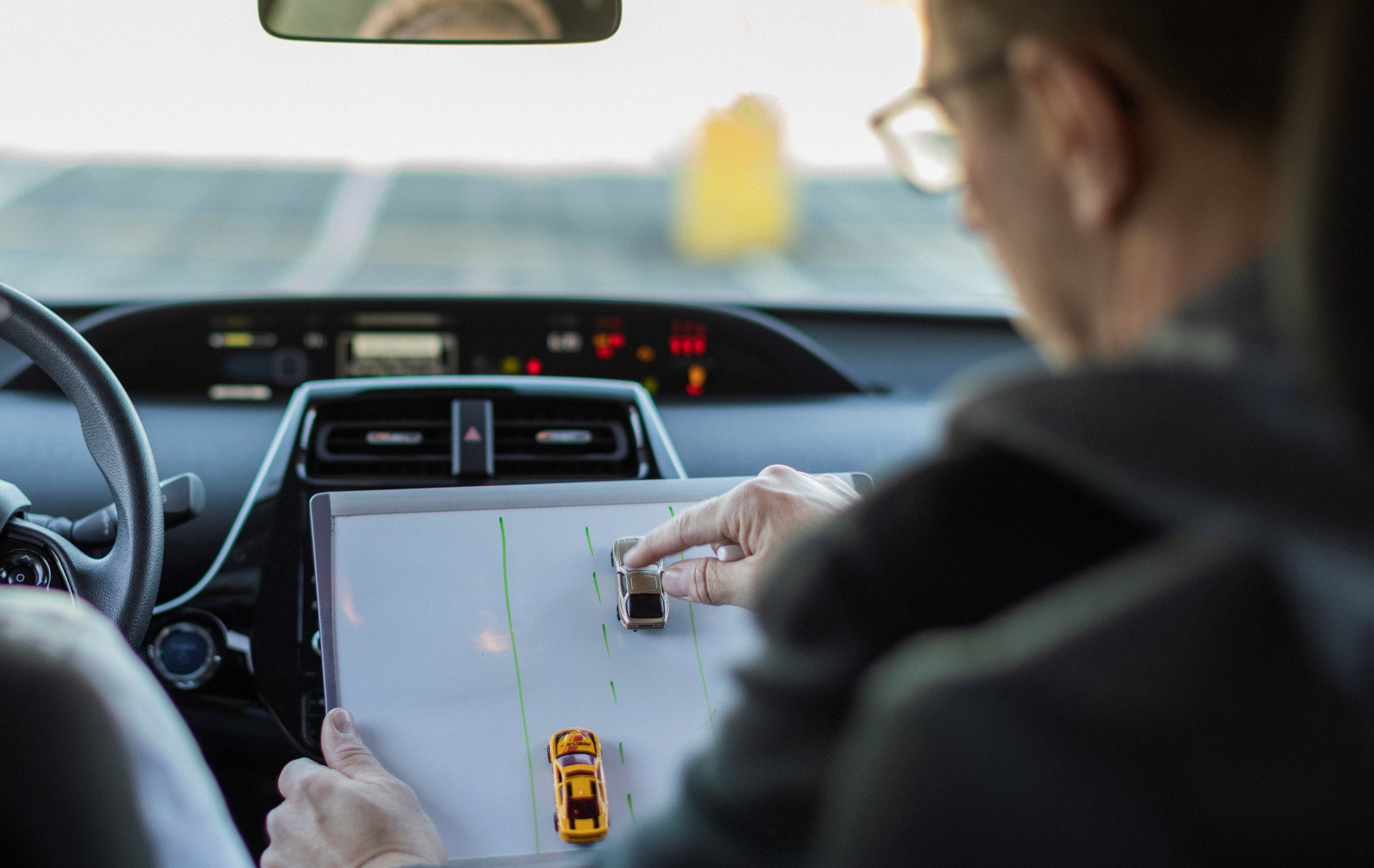 instructor with car models inside a car